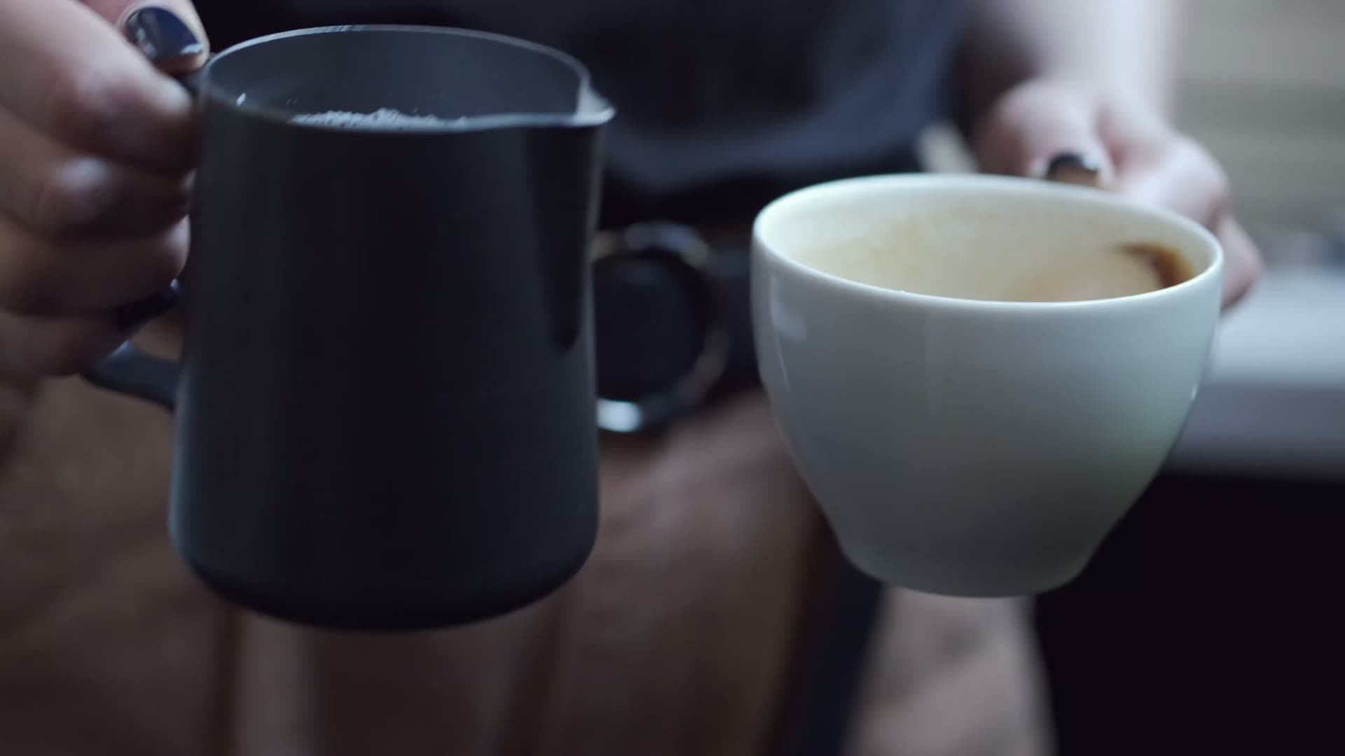 Two hands sharing fresh coffee at Legacy Coffee